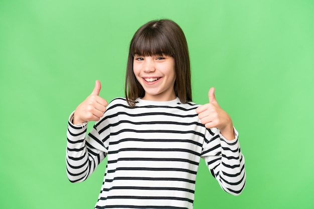 Little caucasian girl over isolated background giving a thumbs up gesture