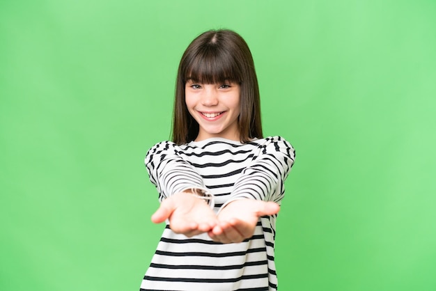 Little caucasian girl over isolated background holding copyspace imaginary on the palm to insert an ad