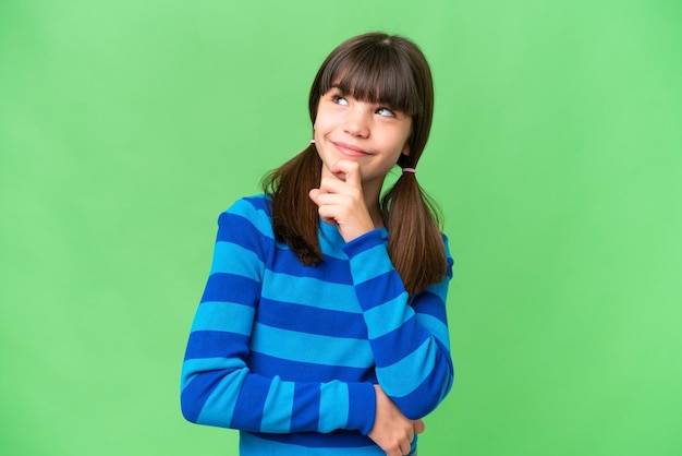 Little caucasian girl over isolated background and looking up