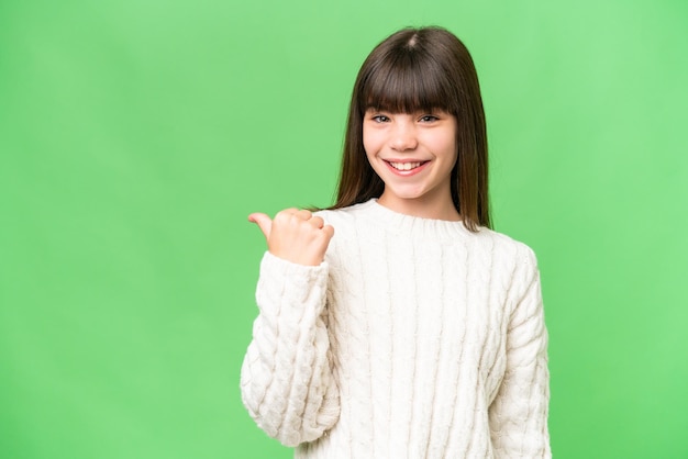 Little caucasian girl over isolated background pointing to the side to present a product