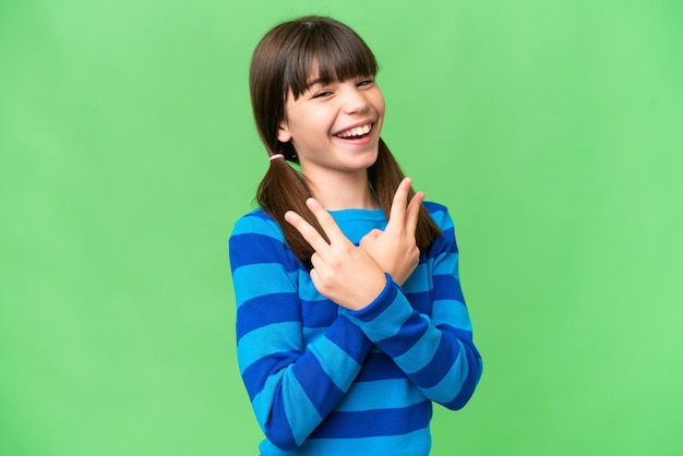 Little caucasian girl over isolated background smiling and showing victory sign