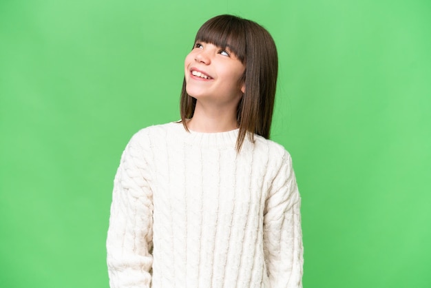 Little caucasian girl over isolated background thinking an idea while looking up