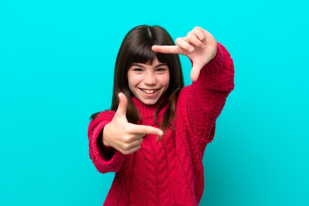 Little caucasian girl isolated on blue background focusing face Framing symbol