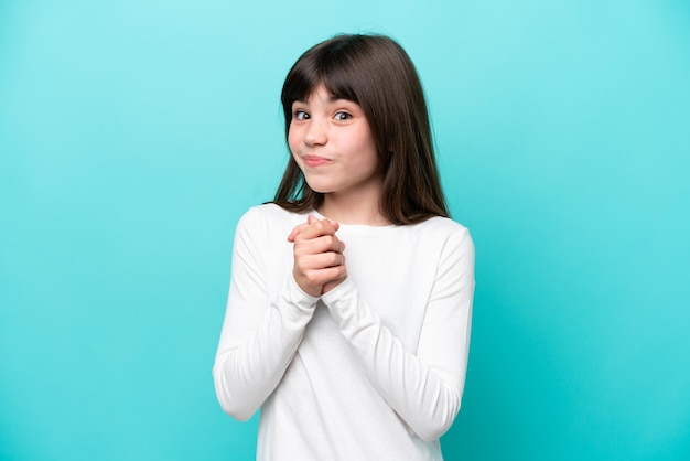 Little caucasian girl isolated on blue background laughing