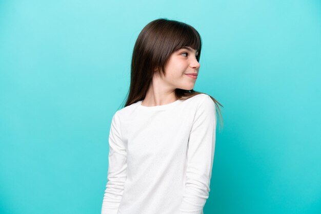 Photo little caucasian girl isolated on blue background portrait