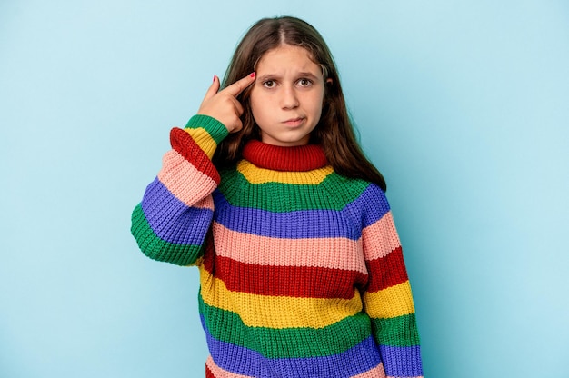 Little caucasian girl isolated on blue background showing a disappointment gesture with forefinger.