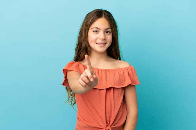 Little caucasian girl isolated on blue background showing and lifting a finger