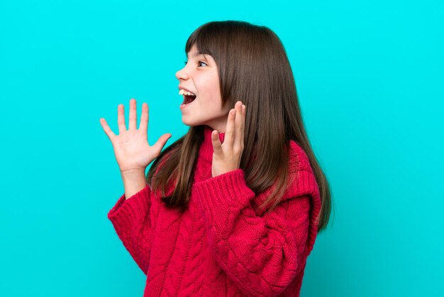 驚きの表情で青い背景に分離された白人少女