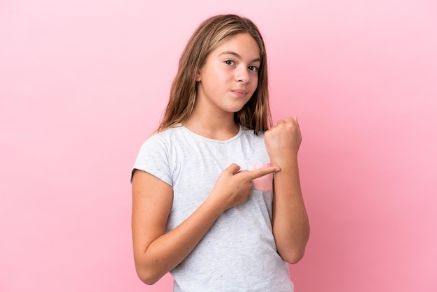 Little caucasian girl isolated on pink background making the gesture of being late