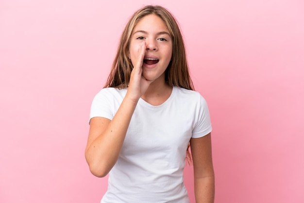 Little caucasian girl isolated on pink background shouting with mouth wide open