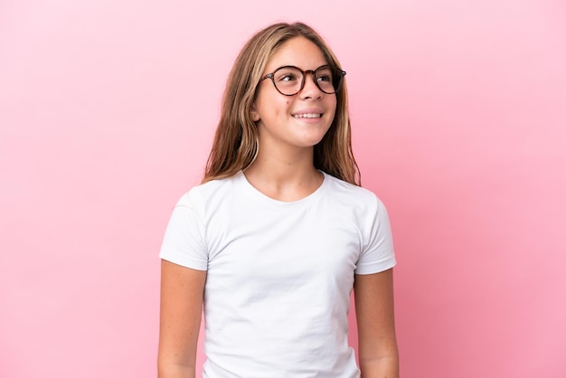 Little caucasian girl isolated on pink background With glasses with happy expression