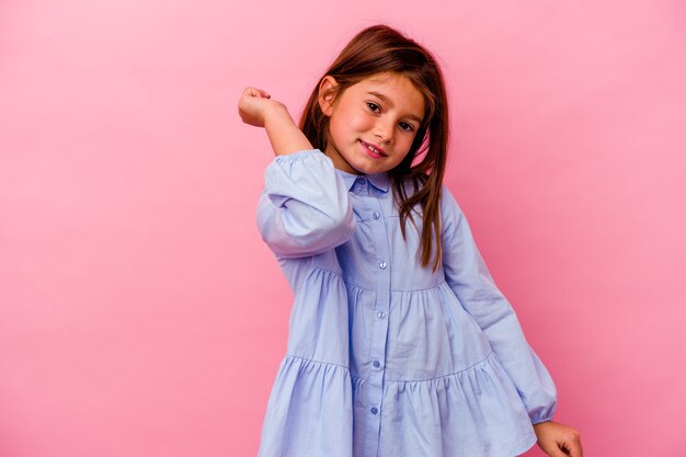 Photo little caucasian girl isolated on pink  dancing and having fun.