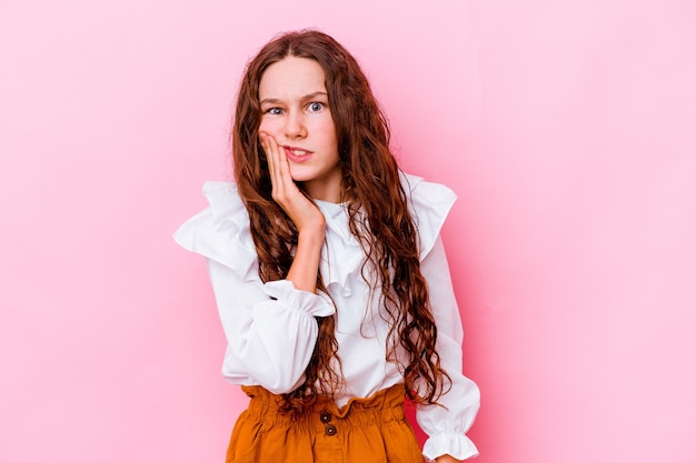 Little caucasian girl isolated on pink having a strong teeth pain, molar ache.