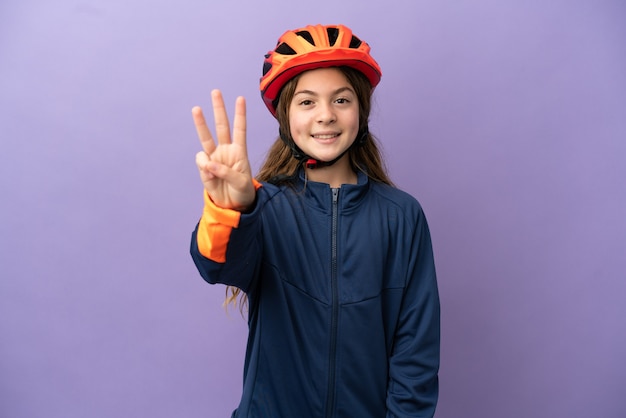 Little caucasian girl isolated on purple background happy and counting three with fingers