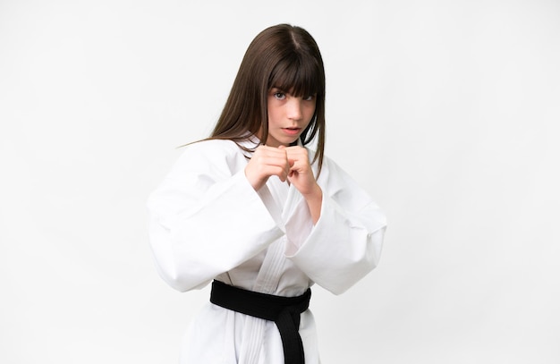 Little caucasian girl over isolated white background doing karate