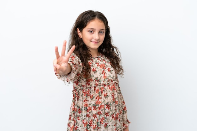 Little caucasian girl isolated on white background happy and counting three with fingers