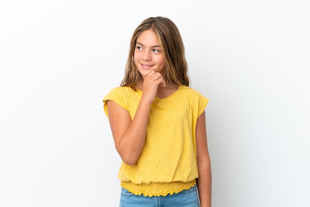 Little caucasian girl isolated on white background looking to the side and smiling