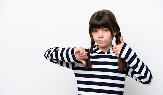 Little caucasian girl isolated on white background making goodbad sign Undecided between yes or not