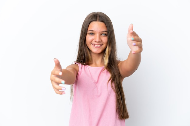 Little caucasian girl isolated on white background presenting and inviting to come with hand