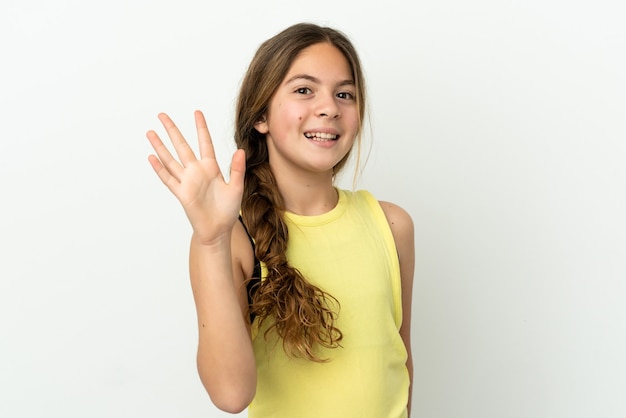 Little caucasian girl isolated on white background saluting with hand with happy expression