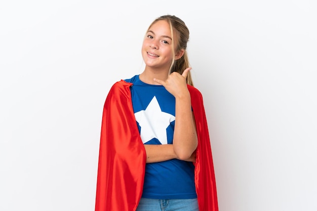 Little caucasian girl isolated on white background in superhero costume and doing phone gesture