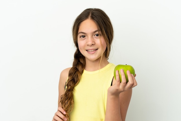 Little caucasian girl isolated on white background with an apple and happy