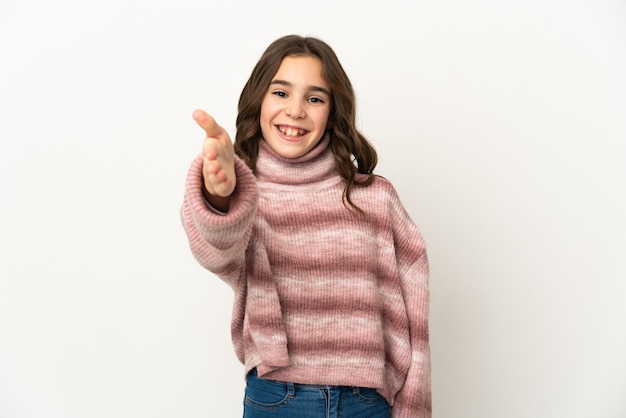 Piccola ragazza caucasica isolata sul muro bianco che agitano le mani per chiudere un buon affare