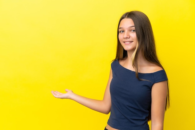 Little caucasian girl isolated on yellow background extending hands to the side for inviting to come