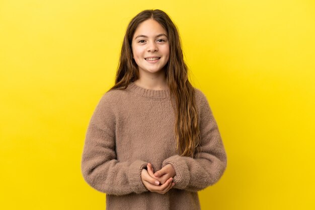 Photo little caucasian girl isolated on yellow background laughing