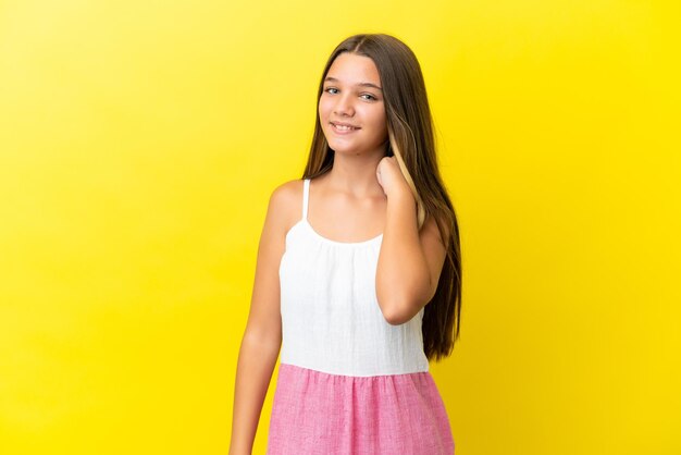 Little caucasian girl isolated on yellow background laughing