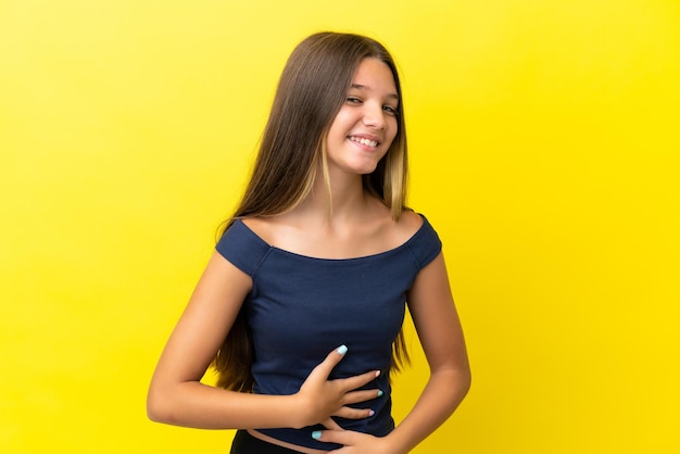 Foto bambina caucasica isolata su sfondo giallo che sorride molto