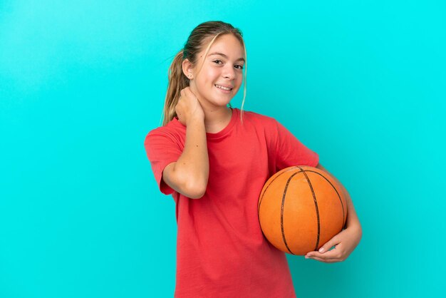 Little caucasian girl playing basketball isolated on blue background laughing