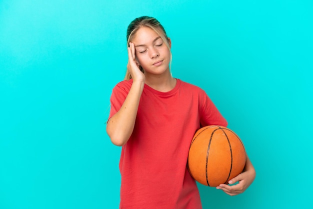 Little caucasian girl playing basketball isolated on blue background with headache