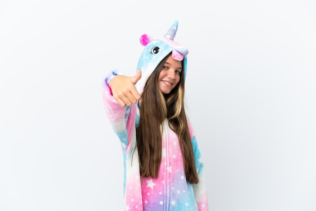 Little caucasian girl wearing unicorn pajama isolated on white background with thumbs up because something good has happened