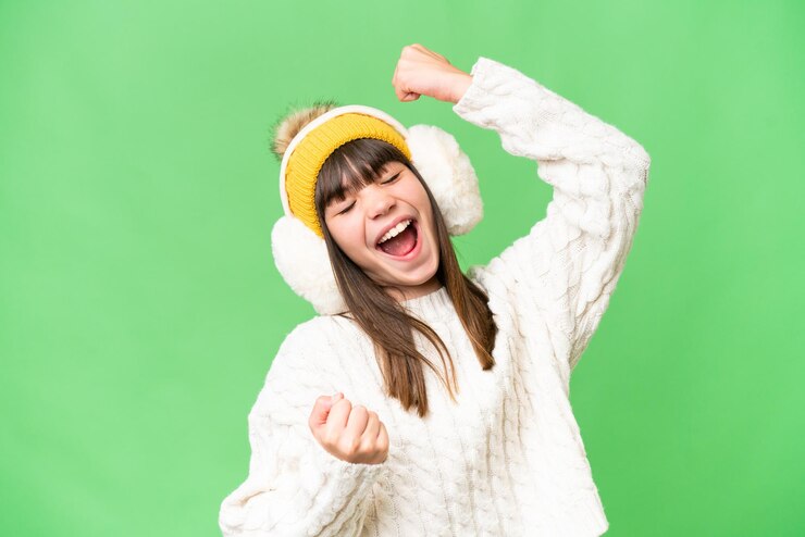 Photo 勝利を祝う孤立した背景に冬のマフを着ている白人少女