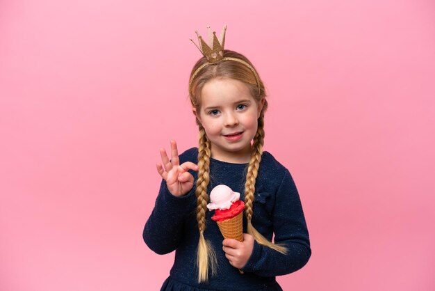 Little caucasian girl with a cornet ice cream isolated on pink background