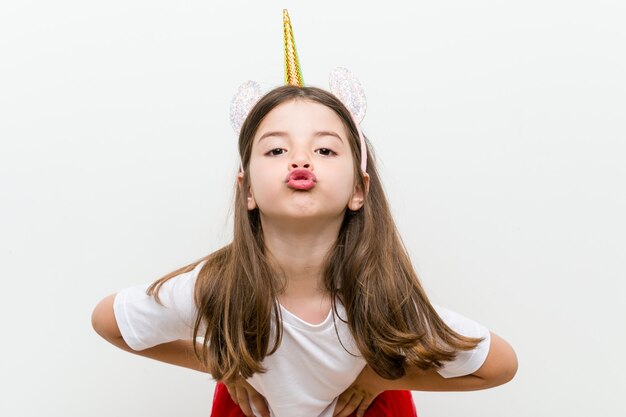 Little caucasian girl with costume and accessories having fun