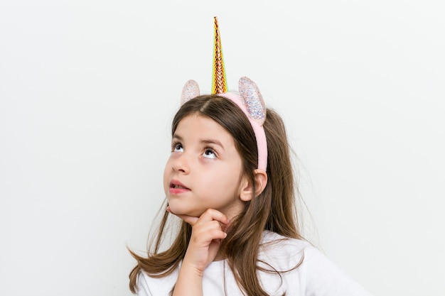 Little caucasian girl with costume and accessories having fun