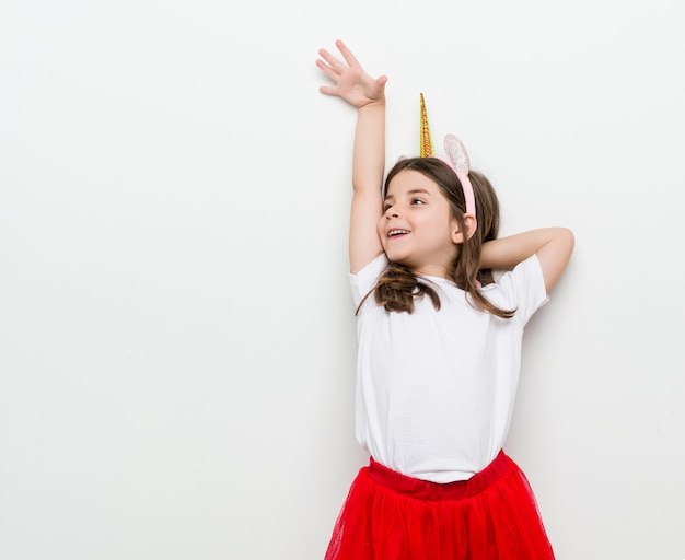 Little caucasian girl with costume and accessories having fun