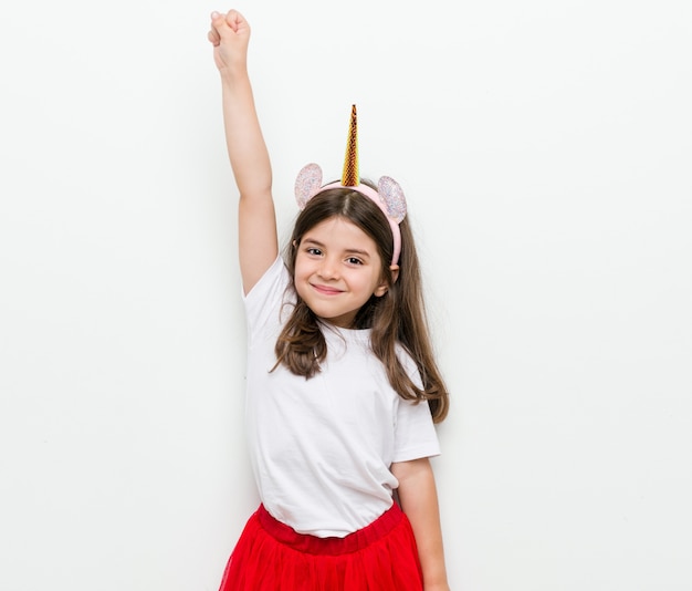 Little caucasian girl with costume and accessories having fun