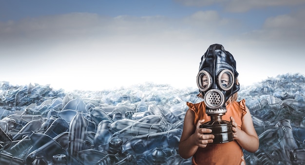 Little caucasian girl with gas mask and mountains of empty plastic bottles behind her.