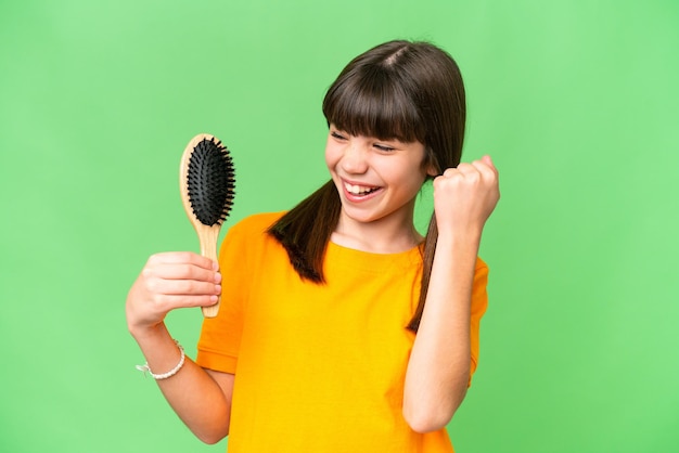 Little caucasian girl with hair comb over isolated background celebrating a victory