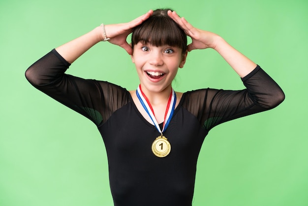 Photo little caucasian girl with medals over isolated background with surprise expression