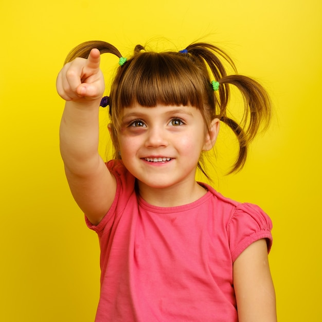 little caucasian girl with pigtails and bruise under the eye and pointing up