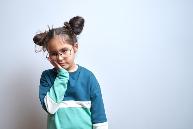 Little caucasian girl with suffering face expression holds cheek with hand touching mouth with palm isolated on white background Toothache dental pain concept