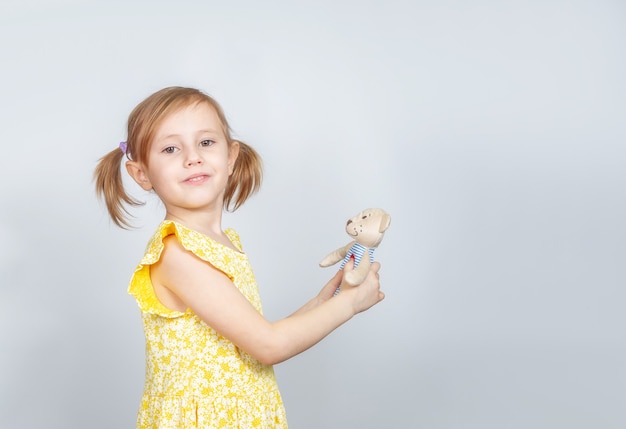 Little Caucasian girl with teddy bear standing