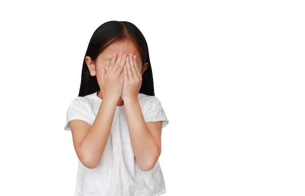 Little caucasian kid girl closing hid eyes by hand isolated  with copy space. Kid is crying and rubbing her eyes with her hands.