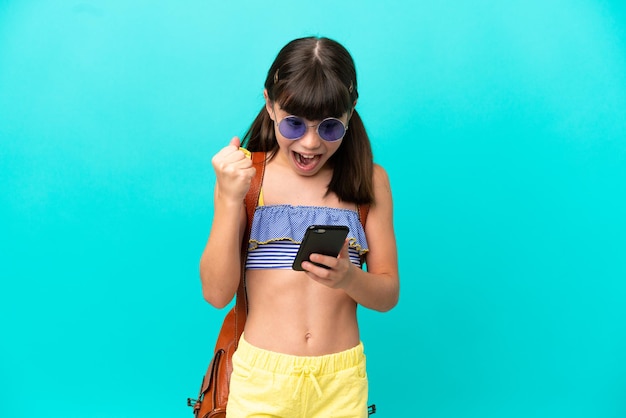 Little caucasian kid going to the beach isolated on blue background surprised and sending a message