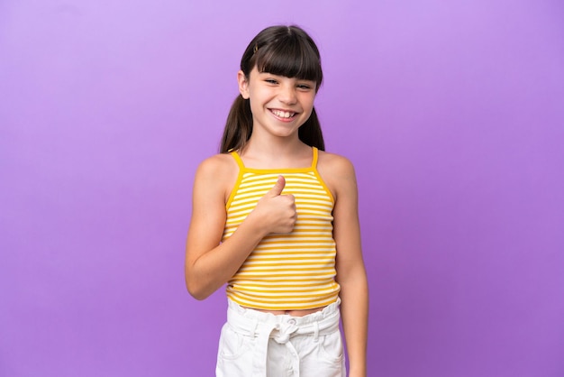 Little caucasian kid isolated on purple background giving a thumbs up gesture