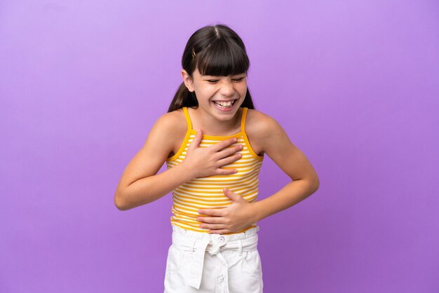 Little caucasian kid isolated on purple background smiling a lot